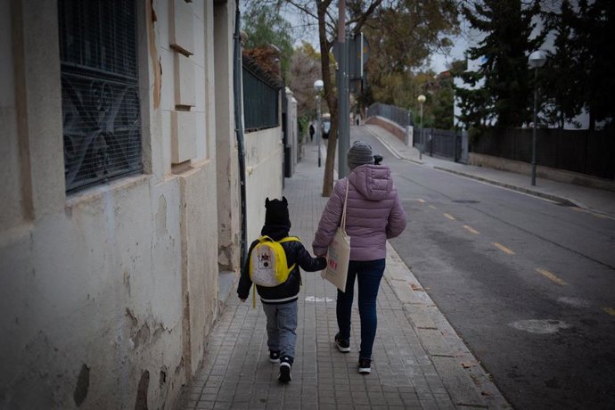 Archivo - Una mujer lleva de la mano a un niño al colegio, en una imagen de archivo