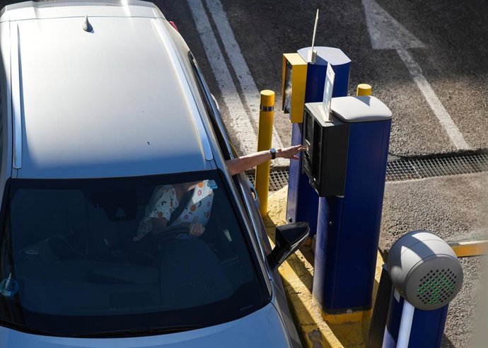 Una conductora obtiene el tique para acceder con su vehículo a un aparcamiento subterráneo.