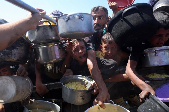 28 de agosto de 2025, Cidade de Gaza, Faixa de Gaza, Território Palestino: Os palestinos esperam para receber alimentos de uma cozinha beneficente depois que o monitor global da fome, a Classificação Integrada da Fase de Segurança Alimentar (IPC), disse q