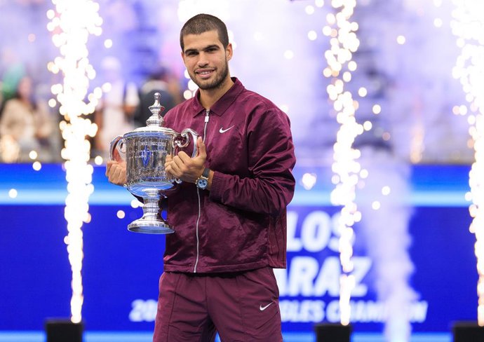 07 September 2025, US, New York: Spanish tennis player Carlos Alcaraz celebrates by holding the trophy after winning the final match against Italy's Jannik Sinner during the 2025 US Open tennis tournament at USTA Billie Jean King National Tennis Center. P