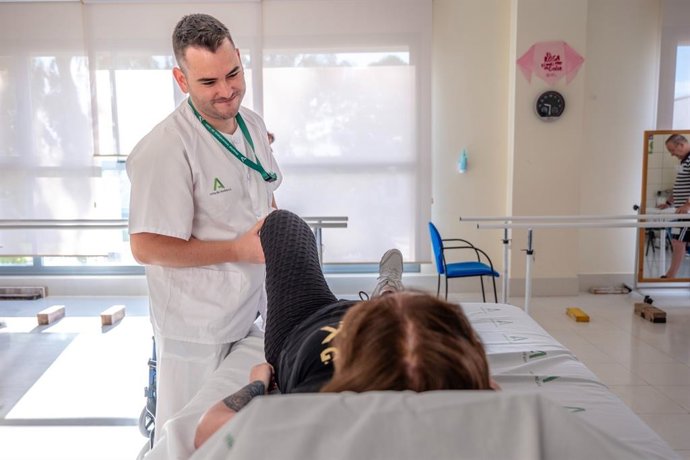 Un profesional de la Unidad de Rehabilitación atiende a una paciente.