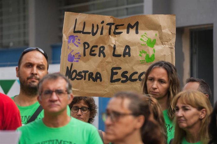 Varias personas con pancartas, durante una rueda de prensa en una protesta por el no inicio del curso, frente a los barracones de Ceip Lluis Vives y la Escuela Infantil Ausiàs March de Massanassa, a 8 de agosto de 2025, en Massanassa. 