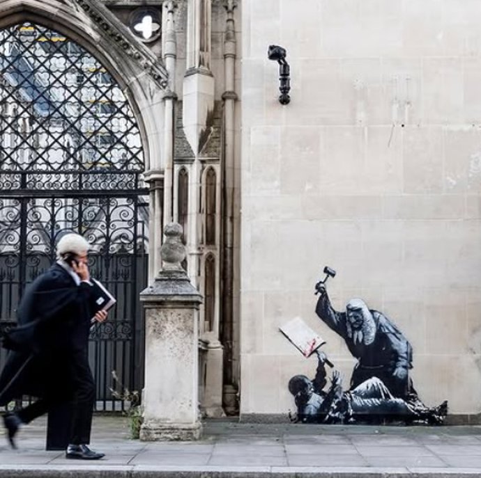 Un mural de Banksy muestra a un juez golpeando a un manifestante en la principal sede judicial de Londres