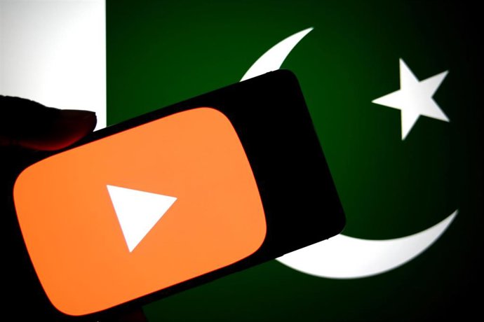 Archivo - Composición con un teléfono móvil delante de la bandera de Pakistán