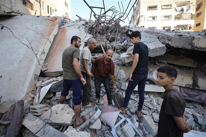 Varias personas inspeccionan los daños causados por un ataque israelí en la ciudad de Gaza