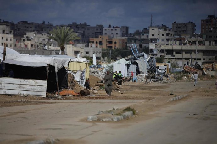 Archivo - Palestinos junto a tiendas de campaña para desplazados en el campamento de Al Bureij, en medio de la ofensiva militar de Israel contra la Franja de Gaza (archivo)