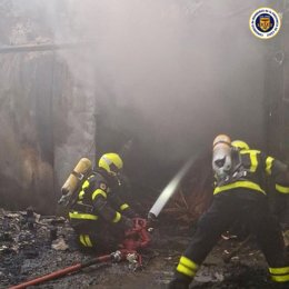 Dos bomberos actuando en el incendio en una fábrica de conservas de Tarifa (Cádiz)