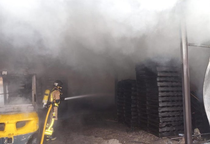 Efectivos del Consorcio de Extinción de Incendios y Salvamento (CEIS) de la Región de Murcia sofocan el incendio declarado en una fábrica de palés en Caravaca de la Cruz