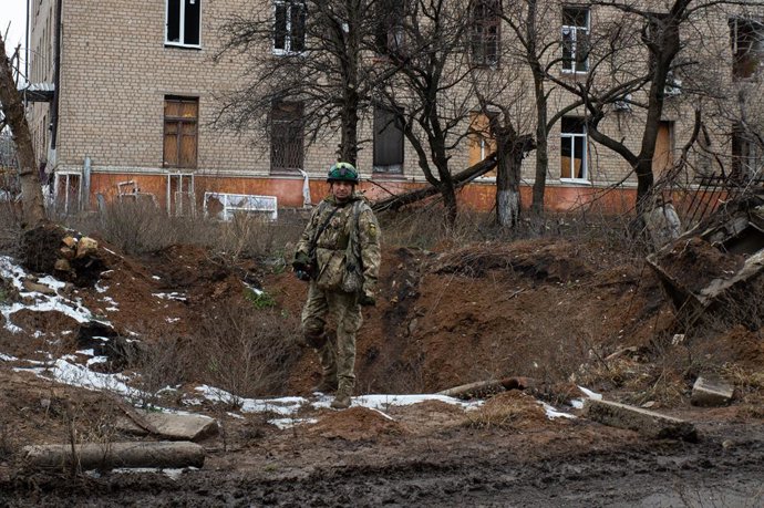 Archivo - Arquivo - Um soldado ucraniano em uma cratera em frente a um prédio de apartamentos em Chasiv Yar, Donetsk oblast, leste da Ucrânia (arquivo).