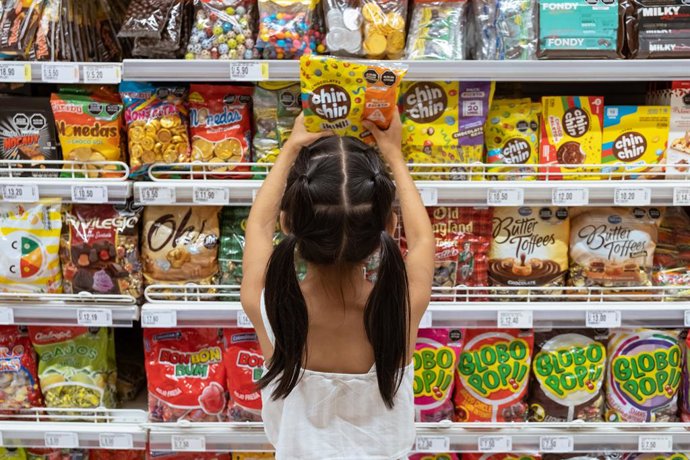 Em 30 de março de 2023, em Lima, Peru, Micaella Delgado, de 8 anos, pega um pacote de doces em uma prateleira de supermercado. Ela escolhe os doces que estão expostos em sua altura.