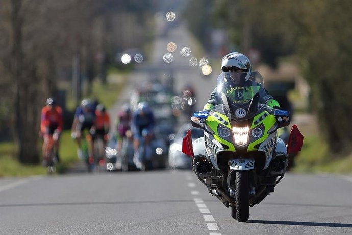 Imagen de archivo de un agente de la Guardia Civil de Tráfico junto al pelotón de La Vuelta a España