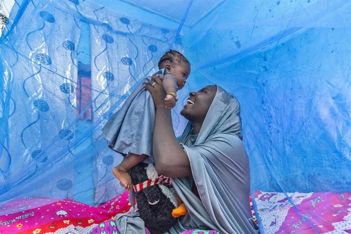 Ummi Inuwa y su hija Ammi se sientan bajo una mosquitera tratada con insecticida en su casa en el estado de Kaduna, Nigeria.
