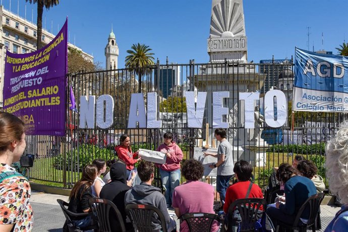 Un grupo de docentes imparte una clase al aire libre bajo una pancarta que dice "No al veto" en el centro de Buenos Aires, Argentina