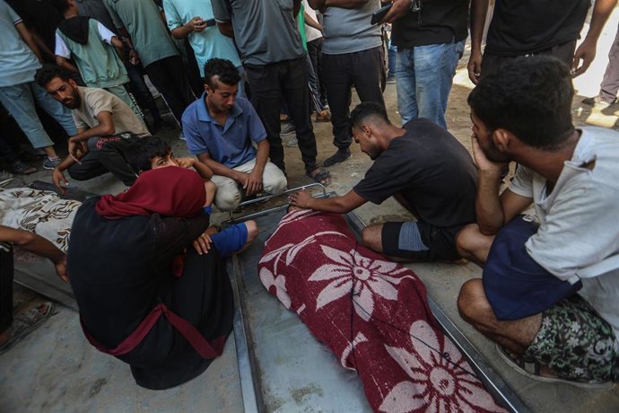 Palestinos junto a un muerto a causa de los ataques ejecutados por el Ejército de Israel contra la Franja de Gaza (archivo)