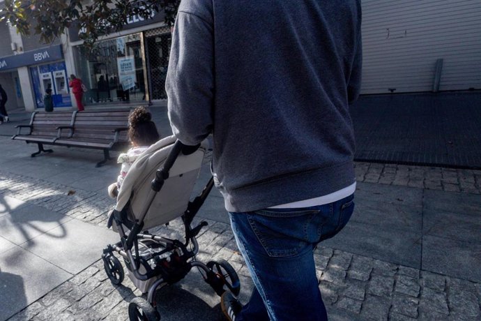 Archivo - Un hombre lleva un carrito de bebé.