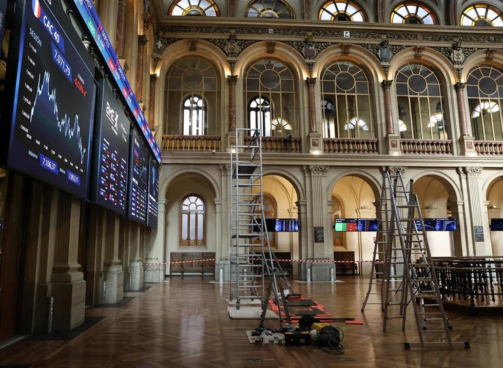 Archivo - Varias escaleras frente a dos paneles del IBex 35, en el Palacio de la Bolsa, a 28 de septiembre de 2023, en Madrid (España).