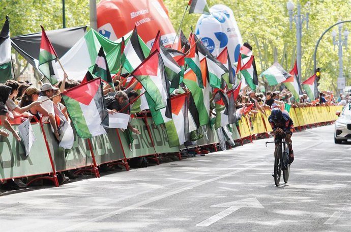 Un ciclista pasa entre los manifestantes durante la 18ª etapa de la Vuelta a España.