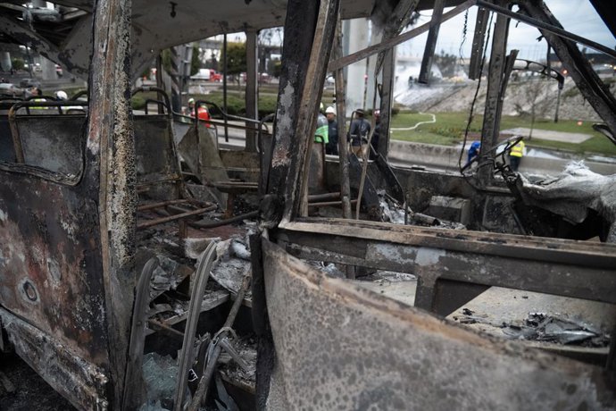Um ônibus queimado é visto no local da explosão que ocorreu quando um caminhão-tanque de gás capotou, causando o trágico acidente que deixou 70 pessoas feridas, três mortas e duas não identificadas na Calzada Ignacio Zaragoza, perto da Puente de la Concor