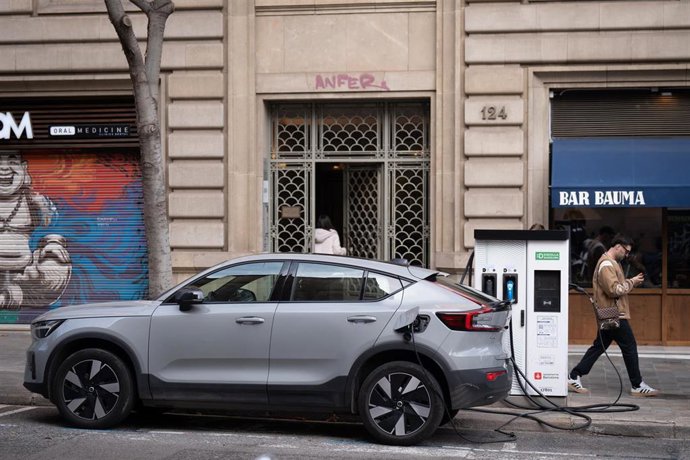 Archivo - Un coche eléctrico cargándose en un punto de carga público de Barcelona