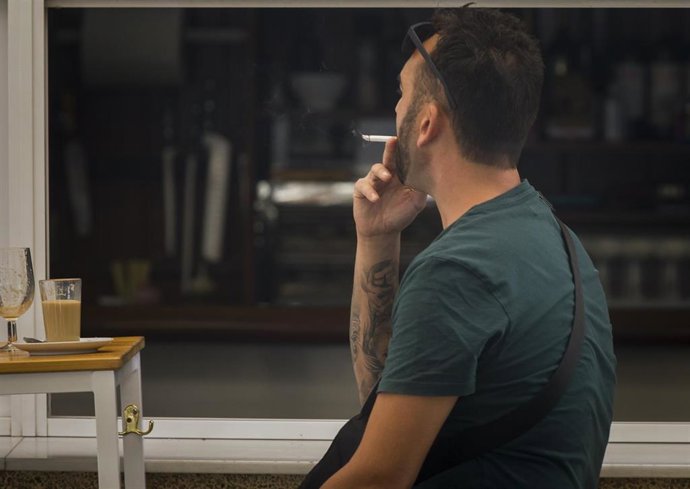 Archivo - Una persona fuma en una terraza  