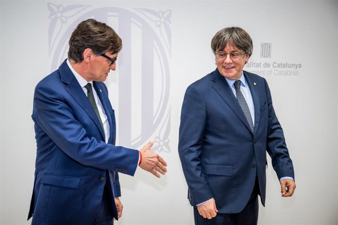 El presidente de la Generalitat, Salvador Illa (i), saluda al presidente de Junts per Catalunya, Carles Puigdemont (d), durante una reunión, a 2 de agosto de 2025, en Bruselas (Bélgica).