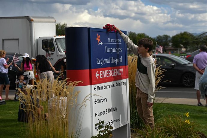 10 de setembro de 2025, Salt Lake City, Utah, EUA: Um menino coloca flores na placa do hospital Timpanogos, para onde o corpo de Charlie Kirk foi levado após o tiroteio. Charlie Kirk foi assassinado durante um evento na Universidade de Utah Valley, em fre