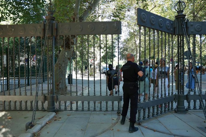 Un empleado de seguridad cierra la puerta de acceso al parque de María Luisa. Imagen de archivo.