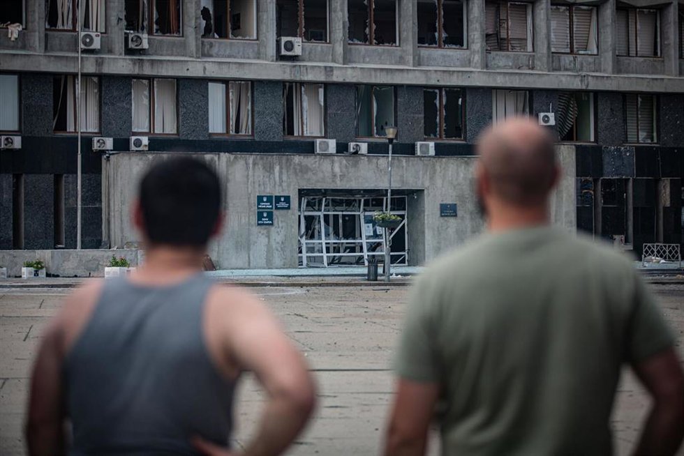 Residentes de Sumi (Ucrania) observan los daños causados por un dron ruso en el edificio administrativo regional