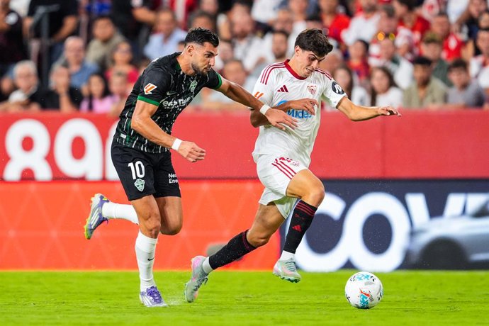 Rafa Mir, do Elche CF, e Juanlu Sanchez, do Sevilla FC, em ação durante a partida de futebol do campeonato espanhol, LaLiga EA Sports, disputada entre Sevilla FC e Elche CF no estádio Ramon Sanchez-Pizjuan em 12 de setembro de 2025, em Sevilla, Espanha.