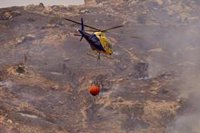 Cerca de 40 bomberos forestales y tres medios aéreos combaten un incendio en Alcaucín (Málaga)