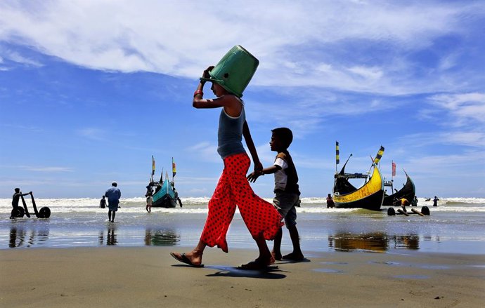 August 26, 2025, Teknaf, Shamlapur, Bangladesh: Children of the fishing village in Shamlapur, Teknaf, wait to collect discarded fish from boats. Despite the health risks, they sometimes find joy in playing amidst poverty and hardship.