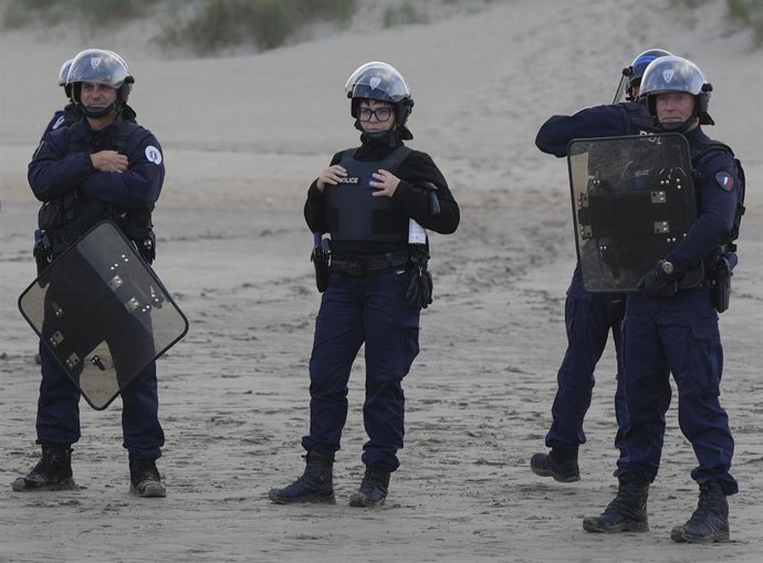 Archivo - Policías esperando a una embarcación con inmigrantes en una playa inglesa (archivo)