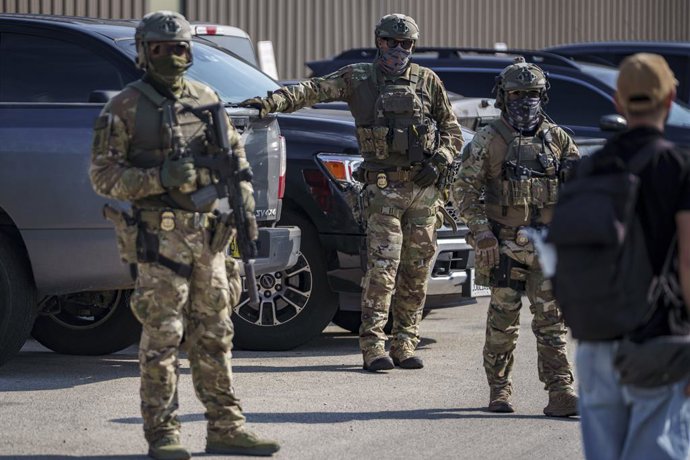 12 de setembro de 2025: Agentes do ICE fortemente armados reunidos em um estacionamento próximo às instalações do ICE em Broadview, gritando perguntas para um jornalista durante um protesto pacífico da "Operação Midway Blitz" em Chicagoland
