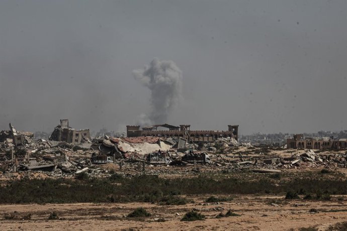 September 13, 2025, Nusairat, Gaza Strip, Palestinian Territory: Smoke rises as Palestinians leave their homes with their belongings along Rashid Street due to intense Israeli military attacks and forced evacuation warnings in the northern Gaza Strip, on 