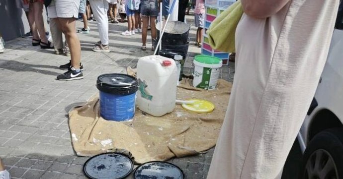 Obreros con cubos de pintura.