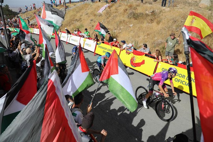Ciclistas passam por uma área com protestos pró-Palestina durante a 20ª etapa da Vuelta Ciclista a España, em 13 de setembro de 2025, em Navacerrada, Madri, Espanha. Os protestos contra a equipe Israel Premier Tech na Vuelta a España foram