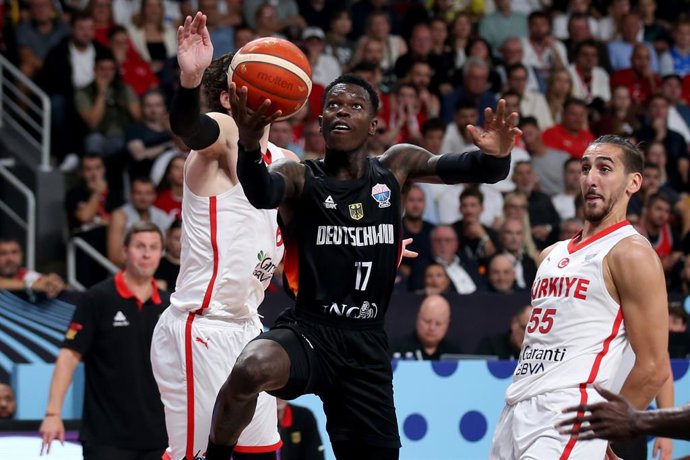 14 de setembro de 2025, Letônia, Riga: Dennis Schroeder (C), da Alemanha, vai para a cesta contra Cedi Osman (L) e Kenan Sipahi, da Turquia, durante a partida de basquete da final do FIBA EuroBasket 2025 entre Turquia e Alemanha em Riga. Foto: Matthias St