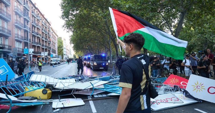 Un joven con una bandera de Palestina en Atocha, el día de la etapa 21 de la Vuelta Ciclista a España, a 14 de septiembre de 2025, en Madrid (España).