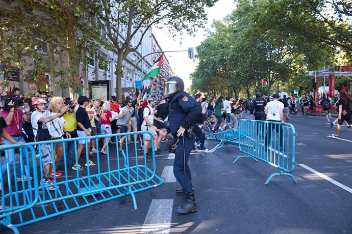 Um agente da Polícia Nacional fica entre cercas derrubadas após acusações policiais contra manifestantes que protestavam a favor da Palestina, no dia da 21ª etapa da Vuelta Ciclista a España, em 14 de setembro de 2025, em Madri (Espanha). A Vuelta Ciclist