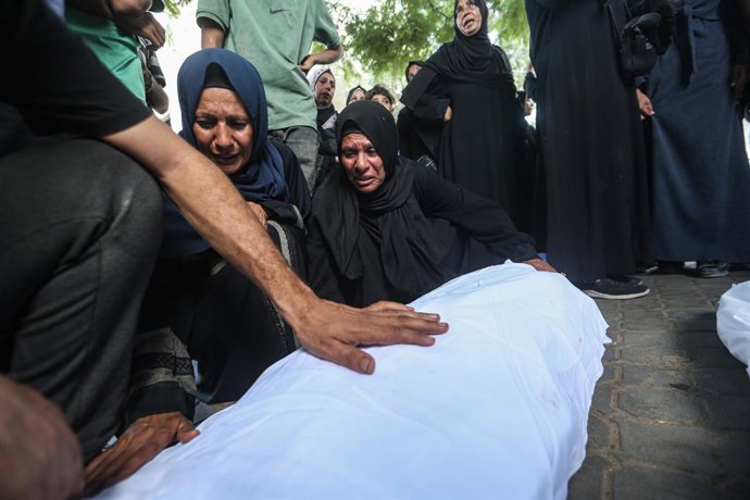 September 15, 2025, Gaza City, Gaza Strip, Palestinian Territory: GRAPHIC CONTENT: Mourners stand near the bodies during the funeral of Palestinians killed in overnight strikes, according to medics, at Al-Shifa Hospital in Gaza City, September 15, 2025