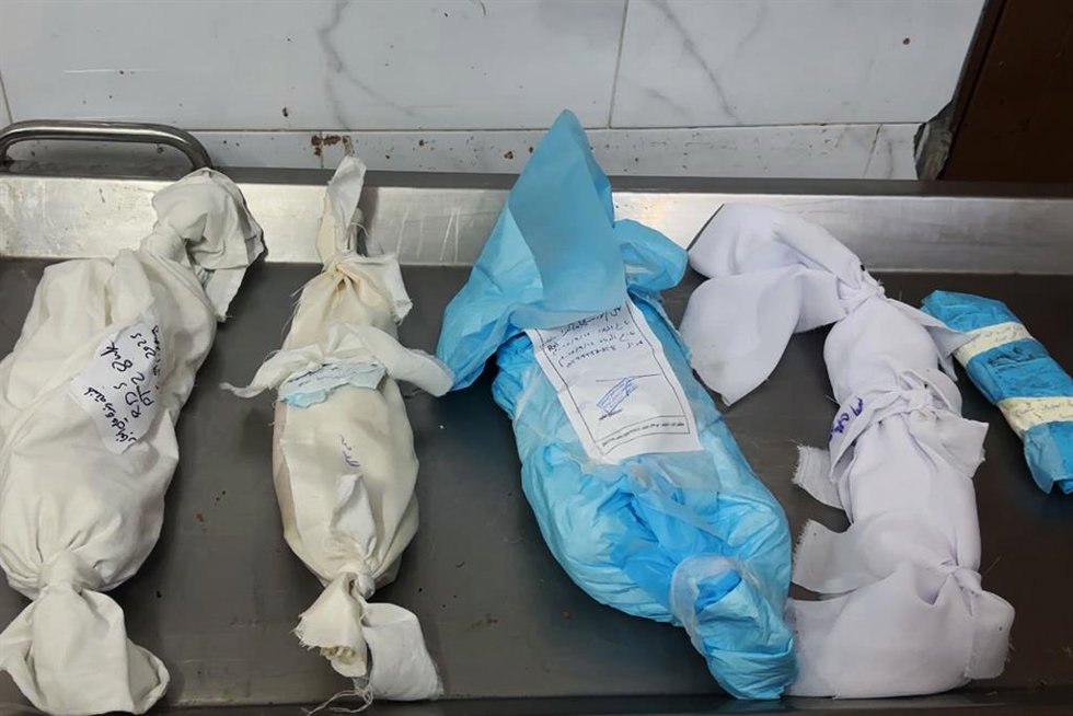 Cadáveres amortajados de cuatro niños palestinos muertos por hambre y desnutrición en la Franja de Gaza a causa de la ofensiva de Israel y sus restricciones a la entrega de ayuda humanitaria a la población del enclave