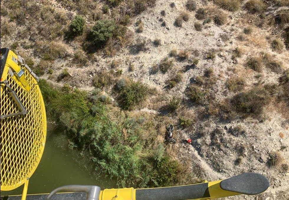 Imagen del accidentado junto a la motocicleta que conducía en el entorno del embalse de Puente, en Lorca (Murcia)