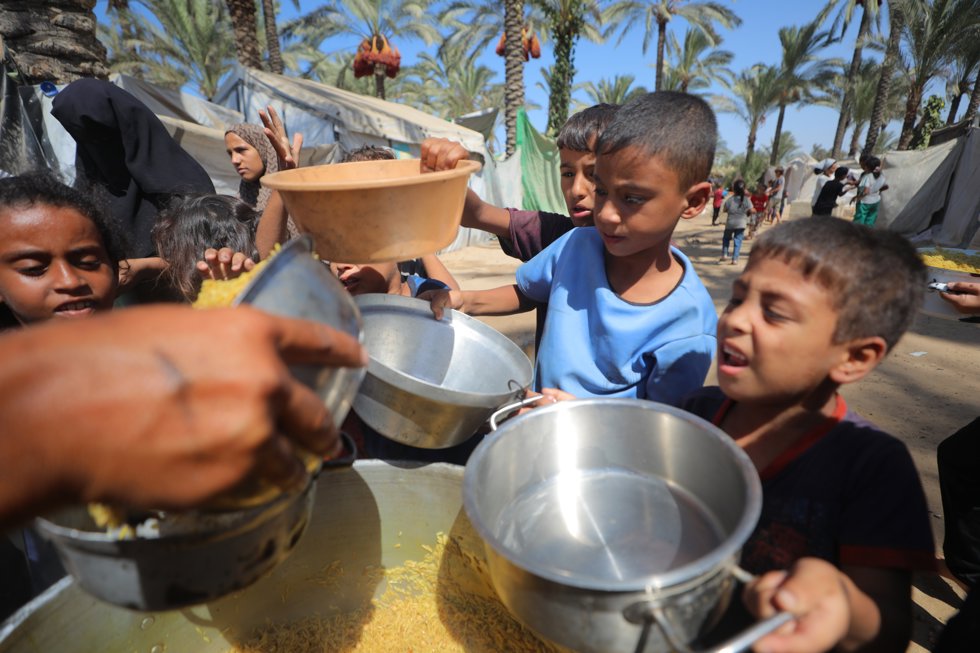 September 21, 2025, Deir Al-Balah, Gaza Strip, Palestinian Territory: Palestinians, including children, try to receive hot meal, distributed by charity organizations, as people struggle with hunger due to Israeli food blockade in Deir al-Balah, Gaza on