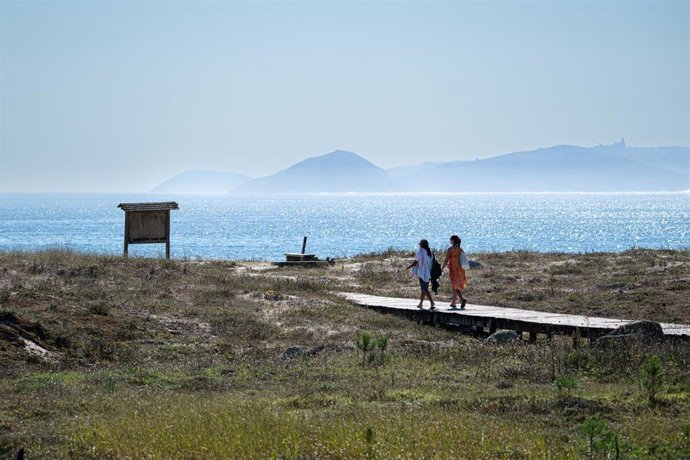 Archivo - Dos personas se dirigen a la playa Silgar, a 30 de septiembre de 2023, en Sanxenxo, Pontevedra, Galicia (España). 