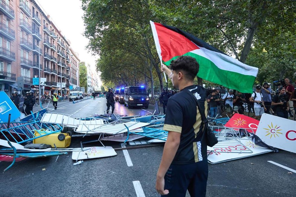 Un joven con una bandera de Palestina en Atocha, el día de la etapa 21 de la Vuelta Ciclista a España