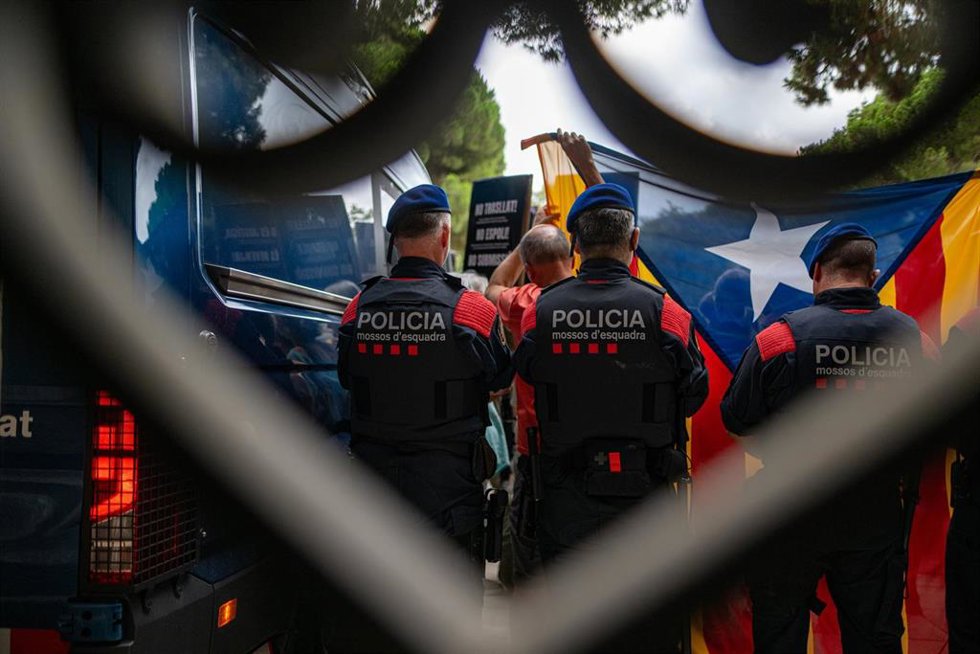 Archivo - Mossos d' escuadra detrás de la bandera estelada, y de activistas, durante la concentración convocada por la ANC en contra de la sentencia que obliga a la Generalitat a devolver las pinturas de Sijena, a 28 de julio de 2025, en Barcelona (Espa