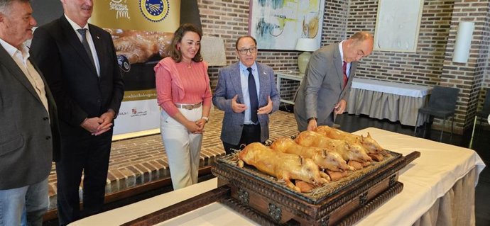 La consejera de Agricultura, Ganadería y Desarrollo Rural, María González Corral, junto al presidente de la Asociación para la promoción del cochinillo de Segovia (Procose), el hostelero José María Ruiz