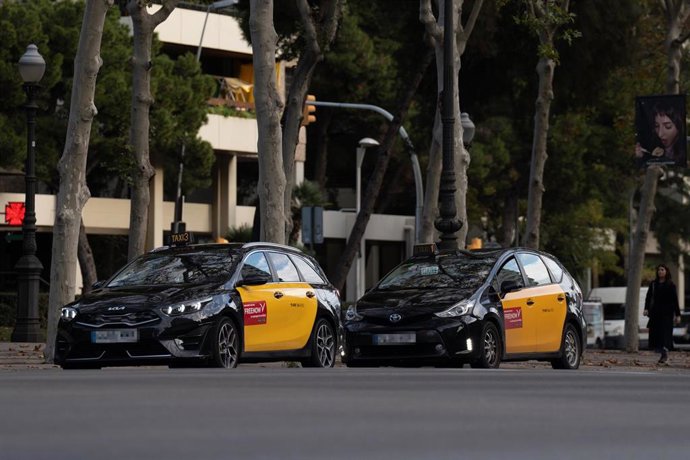 Archivo - Dos taxis circulan en Barcelona, en una imagen de archivo.