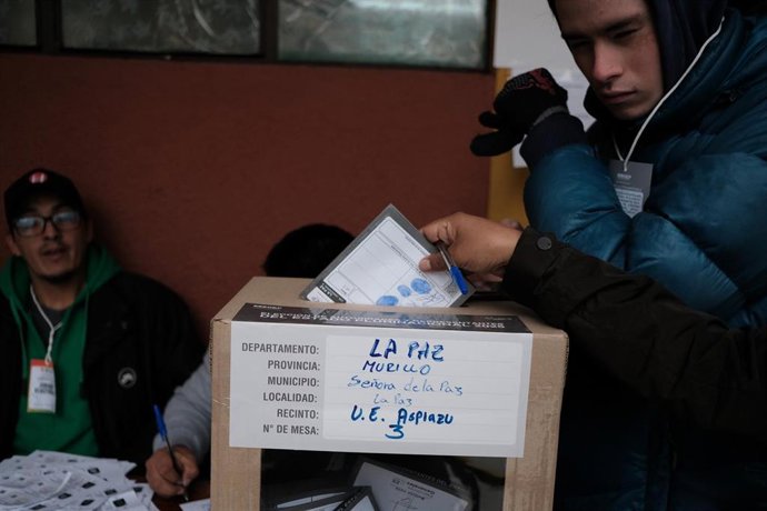 Archivo - Una persona introduce su papeleta en una urna en el marco de las elecciones presidenciales de Bolivia
