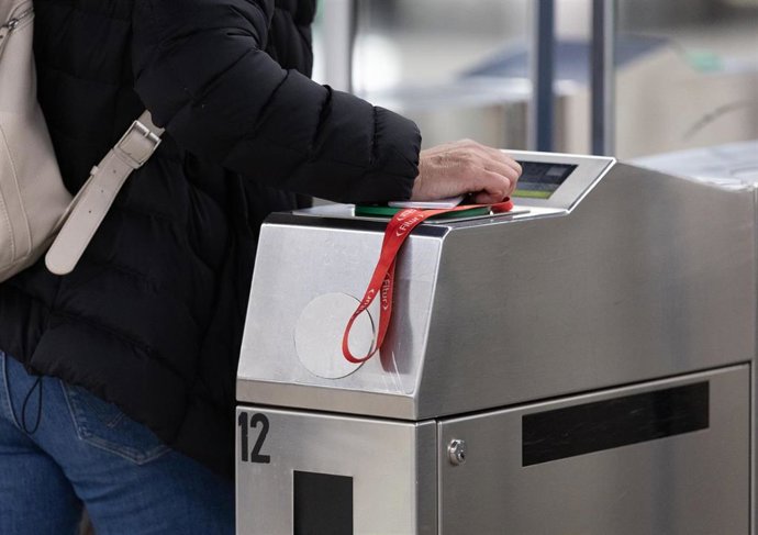 Archivo - Una persona pasa su abono en una estación de Metro